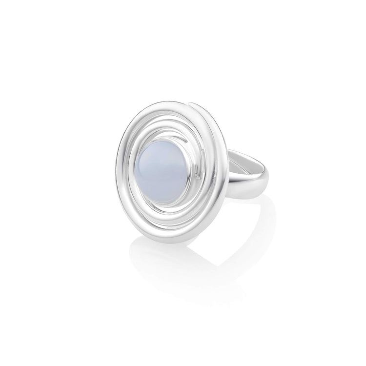 The Silver Ring Open Spiral with Chalcedony by Kaora Sandara Jewelry features a sterling silver band adorned with a circular light blue chalcedony stone, surrounded by concentric metal rings, set against a white background. This description is specific to Size M.