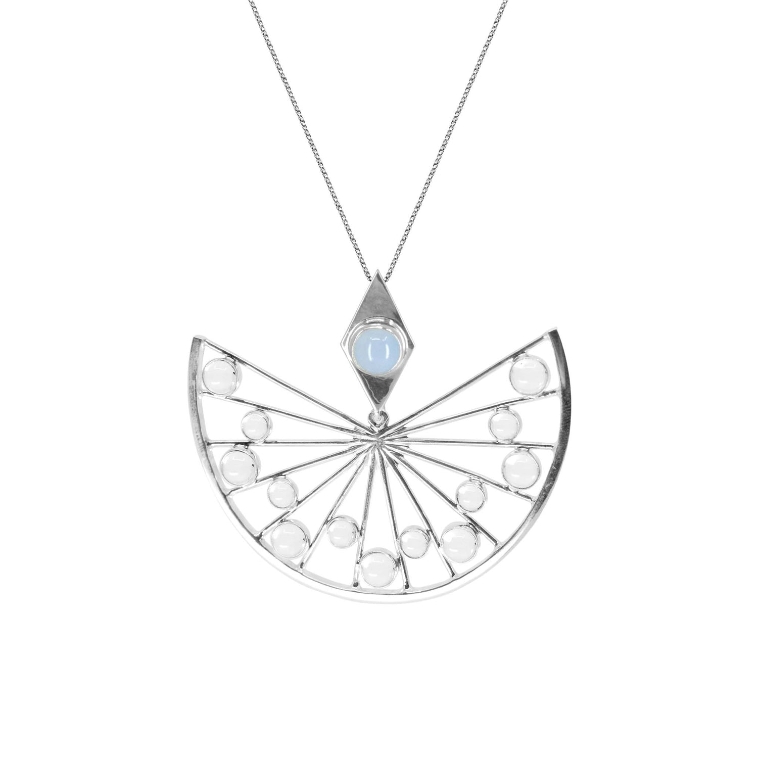 The Higher Self Pendant in sterling silver from Kaora Sandara Jewelry showcases an intricate, fan-like design. This semi-circular pendant features spokes radiating from the center, adorned with small round crystals. A single larger chalcedony gemstone is set within a diamond-shaped frame above the fan, enhancing its spiritual allure.