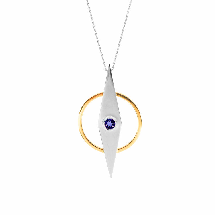 From the Intuition series by Kaora Sandara Jewelry, this necklace features a thin Sterling Silver 925 chain and a stunning geometric pendant. The pendant consists of a gold-plated circle and a rhombus-shaped silver piece, with a small blue amethyst gemstone set in the center of the rhombus.