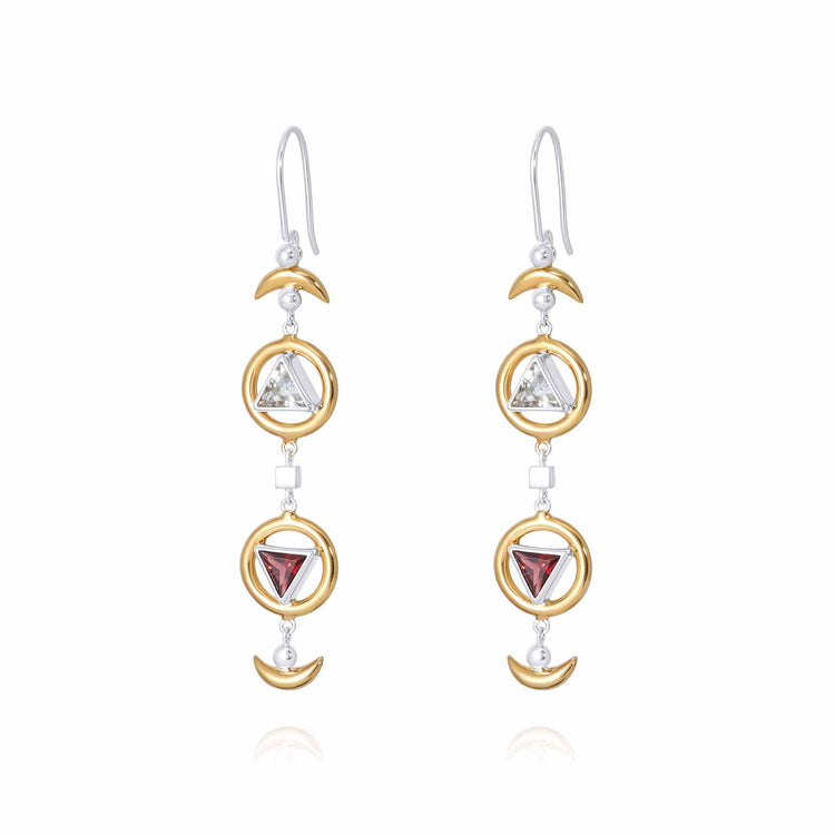 The Resource Earhooks by Kaora Sandara Jewelry feature long, dangling earrings with gold-plated circles and triangular gemstones in blue and red garnet. Each sterling silver earring includes a hook top and crescent-shaped accents adorned with transparent rhinestone crystals that beautifully catch the light.