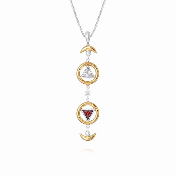 Introducing the Resource Pendant by Kaora Sandara Jewelry: a sterling silver and gold-plated necklace featuring a stunning vertical arrangement of three mesmerizing symbols – a crescent moon, a triangle adorned with a white Rhinestone Crystal, and an inverted triangle showcasing a radiant red garnet. The delicate, thin chain enhances the understated elegance of this exquisite piece.