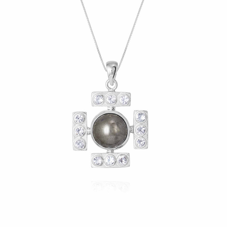 Pendant from the Confidence series, on a white background. The pendant is made of silver, shaped like a cross with a round pyrite stone in the center and rock crystals at the edges.