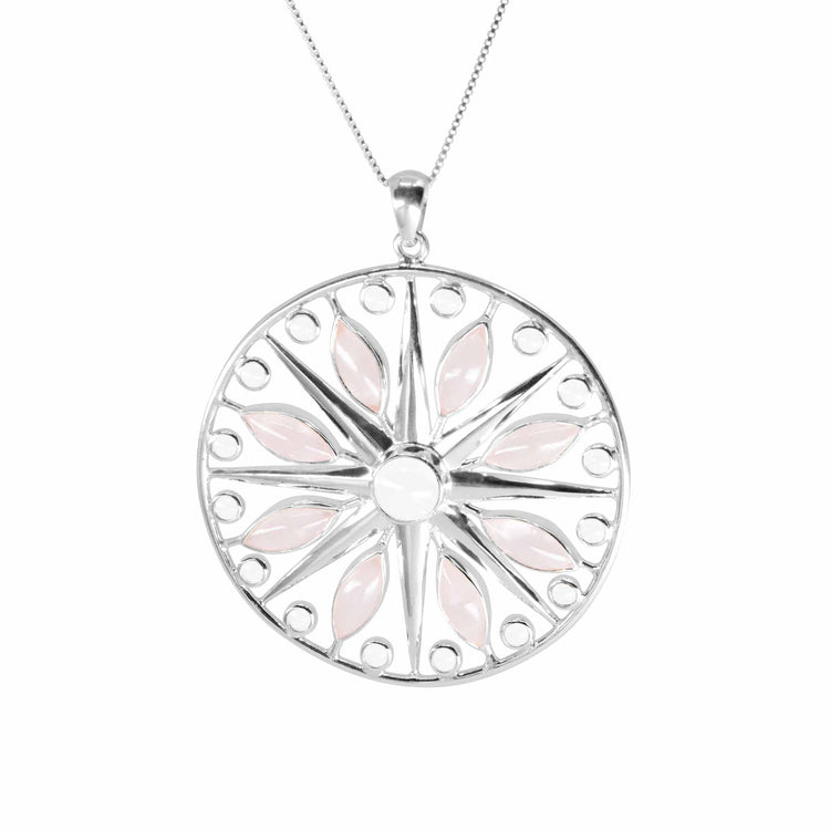 On a white background, a pendant from the Life as Art series, shaped like a circle with inlays of small round rock crystal stones and several rose quartz stones in the shape of petals.