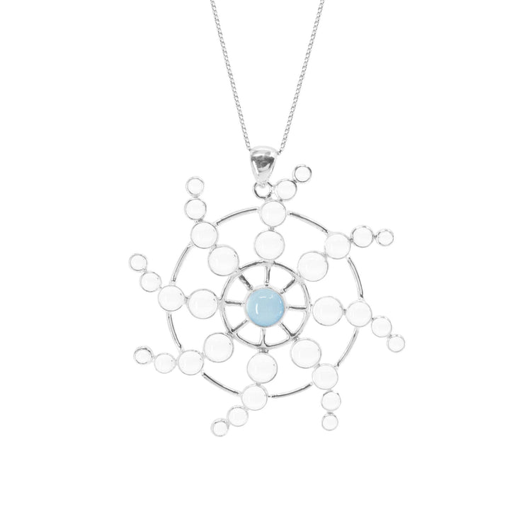 The Kaora Sandara Jewelry "Perfection of Life Pendant" is a delicate sterling silver necklace with a symmetrical web-like design. Featuring circular patterns that radiate from a central light blue Chalcedony gemstone, this elegant piece includes a thin sterling silver chain.