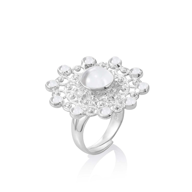 Introducing the Purity Ring - Sterling Silver with Crystal, Size S by Kaora Sandara Jewelry. This exquisite ring from our Purity Collection showcases an intricate, flower-like design adorned with a large, round iridescent stone at its center. Made of Sterling Silver 925, the setting is embellished with smaller rhinestone crystals arranged in a circular pattern to highlight the ring's elegance and detailed craftsmanship.