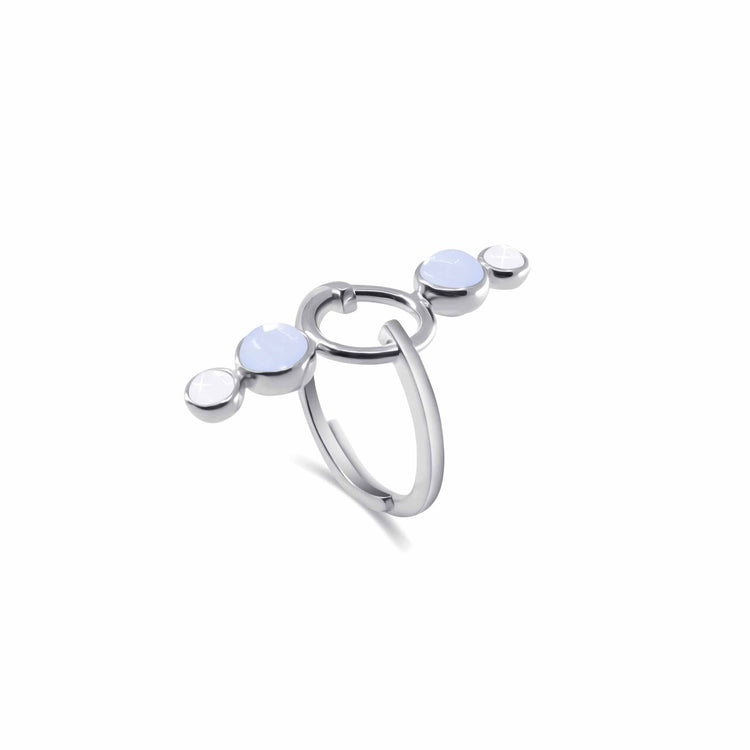 The State Ring by Kaora Sandara Jewelry is a sleek and modern sterling silver piece featuring a unique double band design. This stylish ring showcases three round, light-blue chalcedony gemstones arranged horizontally across the top, with the middle gemstone slightly larger than the two on the sides, creating a contemporary look that exudes inner balance and tranquility.